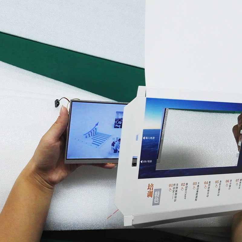 A person holding an open book with a picture on it.